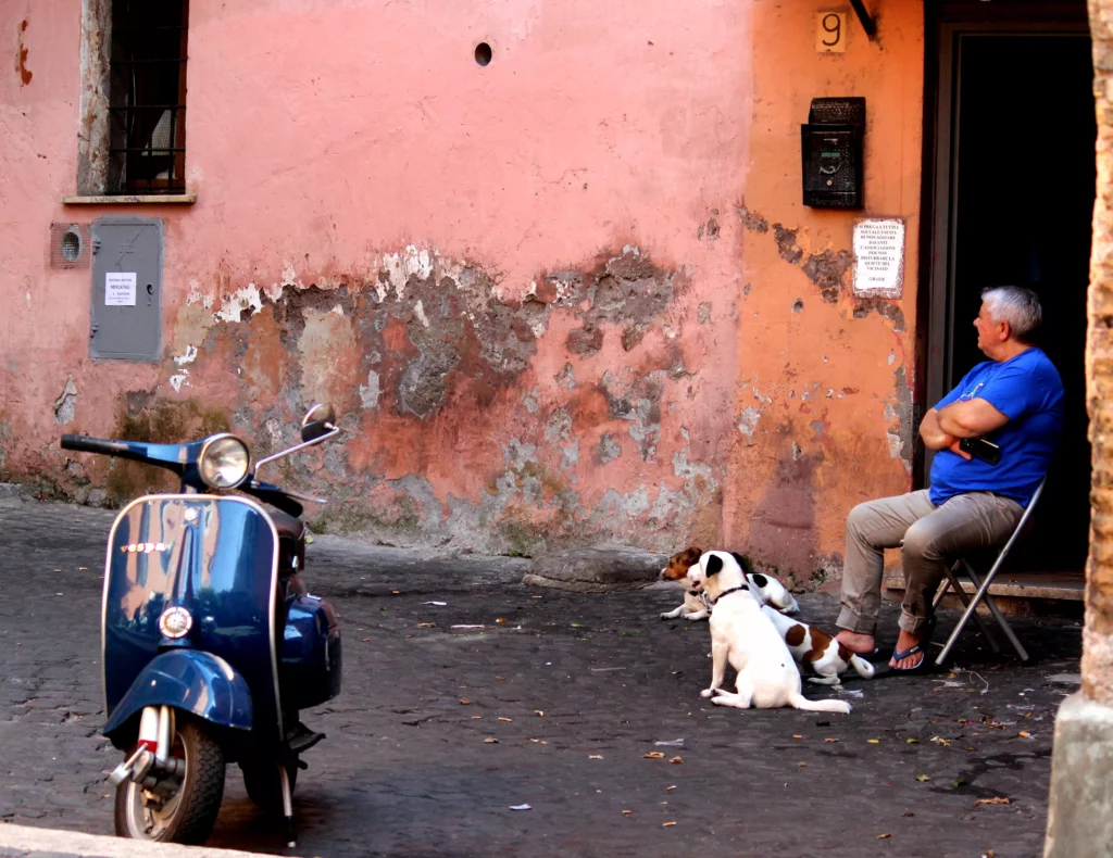 photographies d'Italie Un homme avec ses chiens assis sur une chaise dans la rueTrastevere Rome